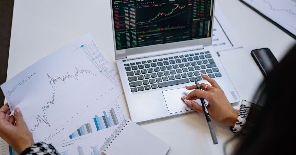 Laptop auf dem Tisch mit Finanzdiagrammen und Auswertungen zur Geschäftsanalyse