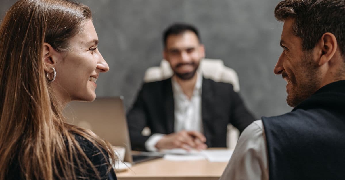 Lächelnde Berufstätige sitzen bei einem freundlichen Meeting in einem Büro zusammen.