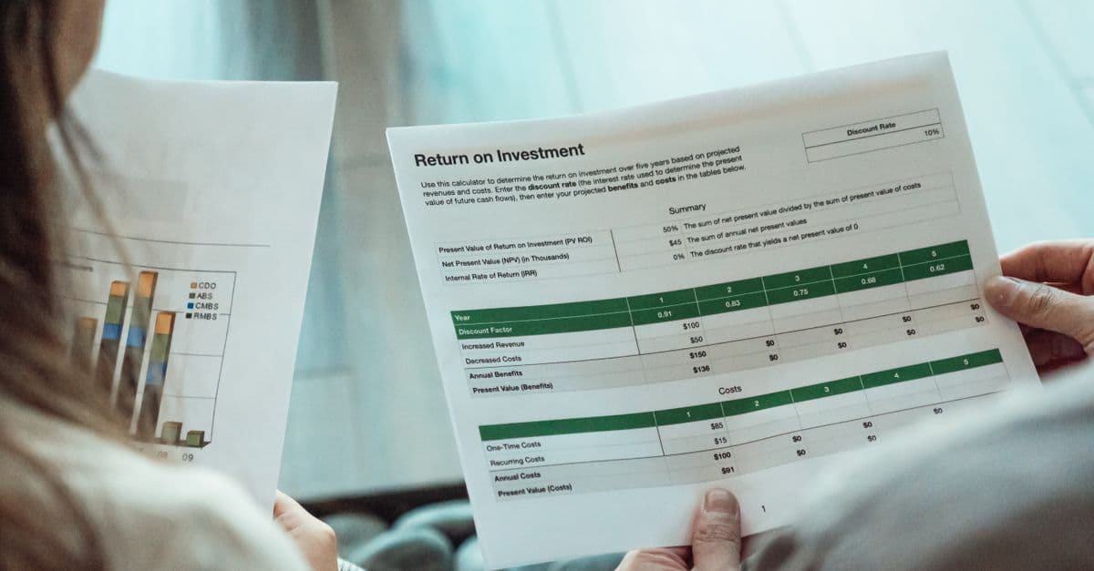 Zwei Personen prüfen gemeinsam Finanzunterlagen zur Renditeberechnung.