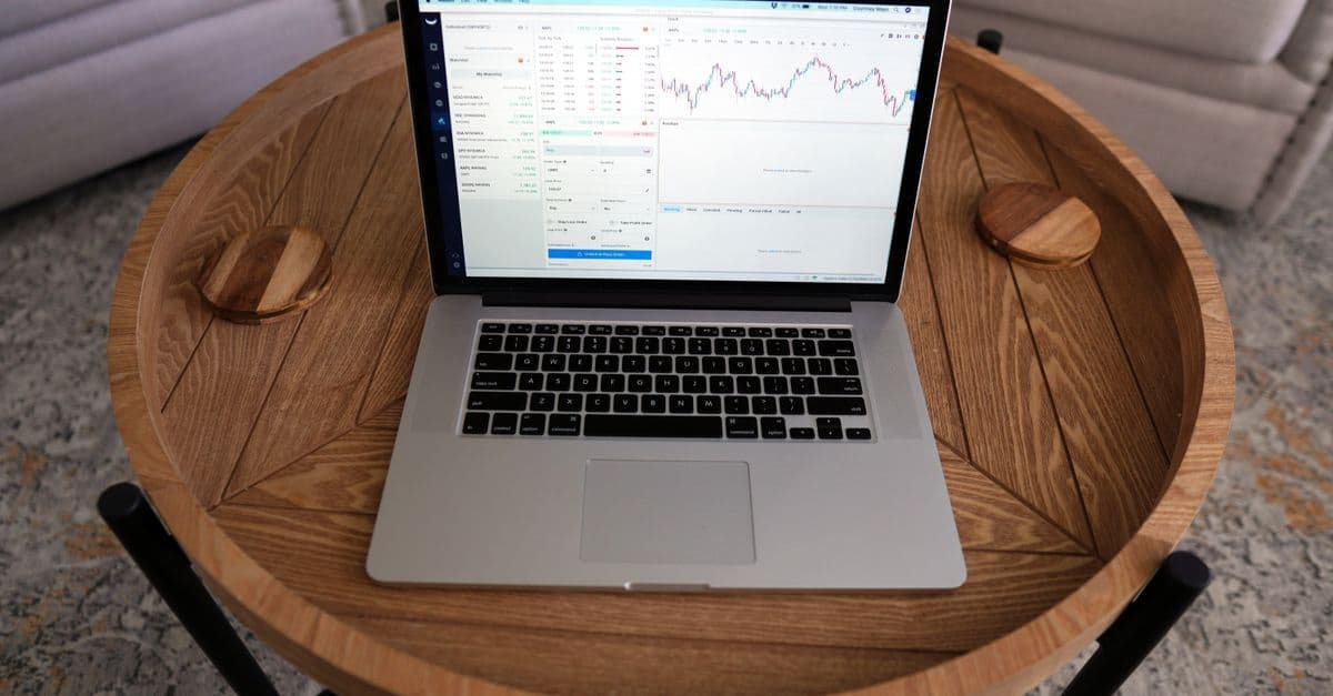 Laptop mit Trading-Charts auf einem Holztisch in Nahaufnahme